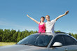 Husband, wife arrange hands in hatch of car in field