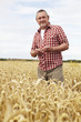 Farmer Inspecting Wheat Crop In Field