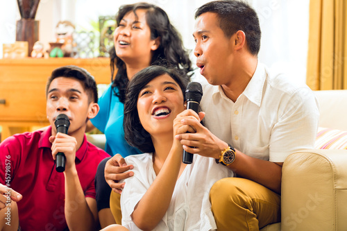 Photo: Asian people singing at karaoke party and having fun Asian people singing at karaoke party and having fun