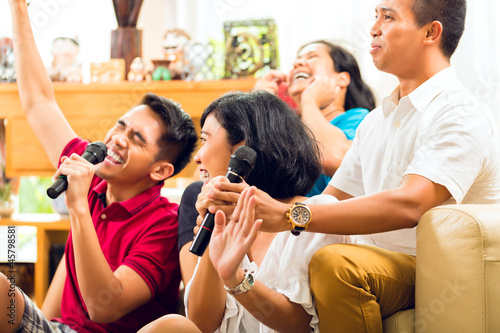 Photo: Asian people singing at karaoke party Asian people singing at karaoke party