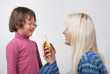 Foto: Mom giving a banana to his daughter Mom giving a banana to his daughter