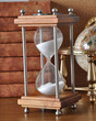 Hourglasses and book on a wooden table
