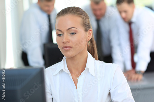 Photo: Young pretty business woman with notebook in the office Young pretty business woman with notebook in the office