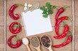 Red chili peppers, garlic, bay leaf, spices, paper on wood