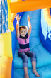 Little Girl sliding down an inflatable Slide