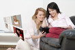 Two friends sharing a computer tablet and chatting