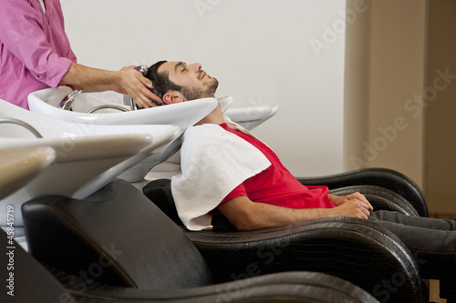 Photo: A male hairdresser washing a male clients hair A male hairdresser washing a male clients hair