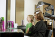 Mother and daughter looking in the mirror in a hairdressers
