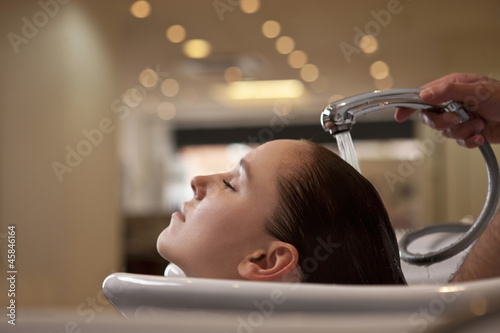 Photo: A woman having her hair washed in a hairdressers close up A woman having her hair washed in a hairdressers close up