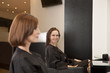 Two female clients sitting in a hairdressing salon