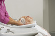 A senior woman having her hair shampooed at a hairdressing salon