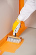 builder brush applied waterproofing on the floor of the bathroom