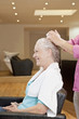Senior woman having product applied by hairdresser, close up