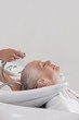 A senior woman having her hair washed at hairdressers, close up