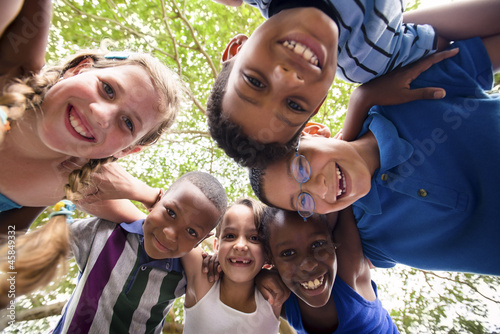 Photo: Children embracing in circle around the camera and smiling Children embracing in circle around the camera and smiling