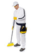 Photo: construction worker in white overalls sweeping with a broom on w construction worker in white overalls sweeping with a broom on w