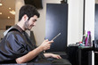A male client looking at a digital tablet in a hairdressers
