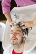 A male hairdresser shampooing a male clients hair