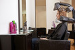 Woman looking at herself in a mirror in a hairdressing salon