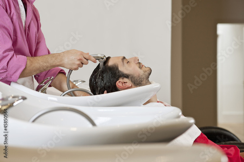 Photo: A male hairdresser washing a male clients hair A male hairdresser washing a male clients hair