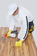 Photo: worker cleans with sponge and spray wooden floor before tilling worker cleans with sponge and spray wooden floor before tilling
