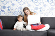 young happy mother and child with laptop at home