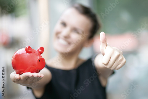 Photo: zufriedene Frau mit Sparschwein zufriedene Frau mit Sparschwein