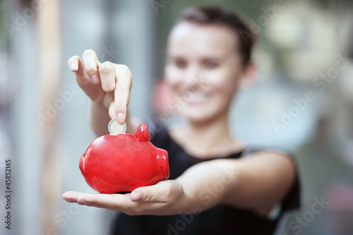 Photo: junge Frau mit Sparschwein junge Frau mit Sparschwein