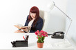 Confident business woman reads book in a modern office