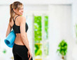woman holding a yoga mat