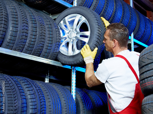 Photo: Car mechanic stores winter tires for tire changing Car mechanic stores winter tires for tire changing