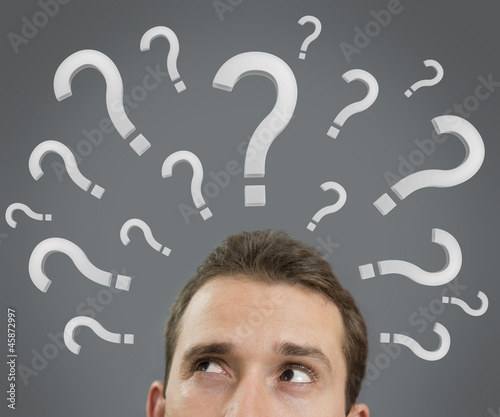 Photo: Man thinking concept with question marks close up Man thinking concept with question marks close up