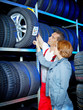 Motor mechanic explains tire labeling to a customer in a garage