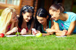 group of happy college girls chatting in network on green lawn