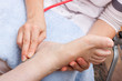 Ärztin untersucht Fuss einer Patientin
