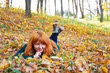 Beautiful woman lying on fall leaves