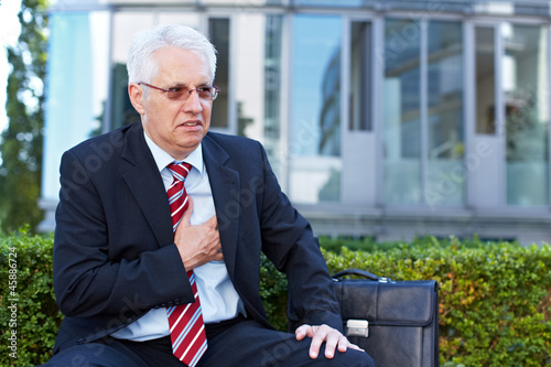Photo: Senior hält sich schmerzende Brust Senior hält sich schmerzende Brust