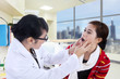Photo: Doctor checking patient throat Doctor checking patient throat
