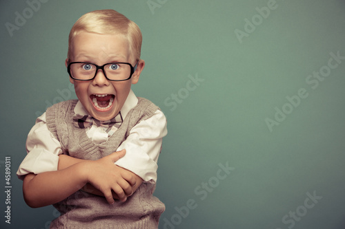 Photo: Cheerful smiling funny boy on a green background. Cheerful smiling funny boy on a green background.