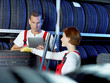 Car mechanics work in a warehouse for tires with touchpad