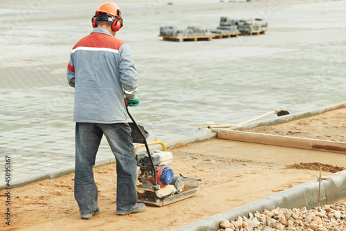 Photo: concrete worker work with compactor concrete worker work with compactor