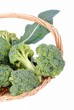 organic broccoli in a straw basket, isolated on white