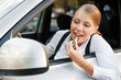 female painting her lips and driving the car