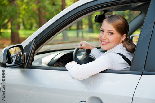 Photo: young woman driving the car and smiling young woman driving the car and smiling