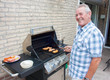 Retired dutch senior man grilling hamburgers