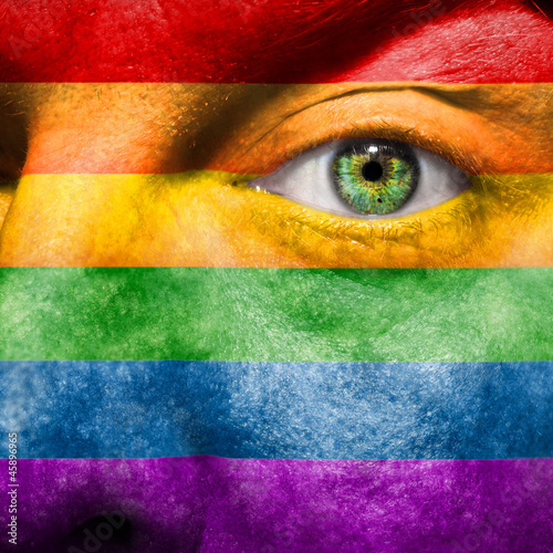 Photo: Rainbow Flag painted on face to show gay pride support Rainbow Flag painted on face to show gay pride support