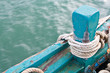 mooring rope tied around green wood anchor