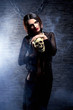 Halloween concept: young and sexy witch holding a human skull