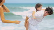 Caucasian father giving daughter piggyback on beach
