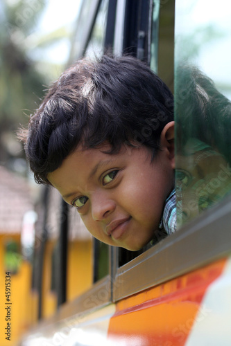 Photo: Handsome and cute little indian school kid looking back with hap Handsome and cute little indian school kid looking back with hap